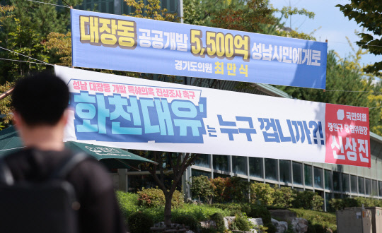 경기도 성남시청 인근 교차로에 성남 대장동 개발 사업과 관련해 더불어민주당 소속 경기도의회 의원과 국민의힘 지역 당협위원장 이름으로 상반된 의미를 담은 현수막이 나란히 걸려 있다. 연합뉴스